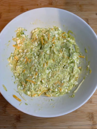 Bowl of mashed avocado mixture with cheese