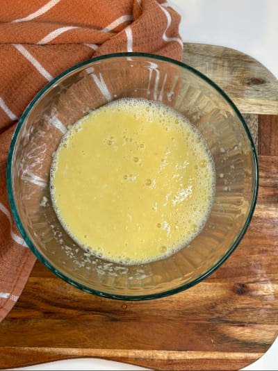 Beaten eggs in glass mixing bowl