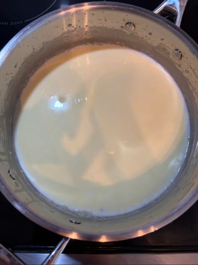 Saucepan of milk heating on stovetop