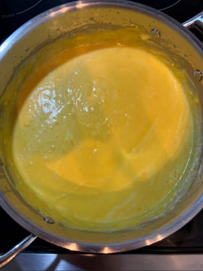 Creamy yellow soup in saucepan