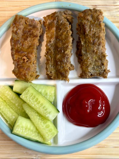 Breaded strips with cucumber slices and ketchup